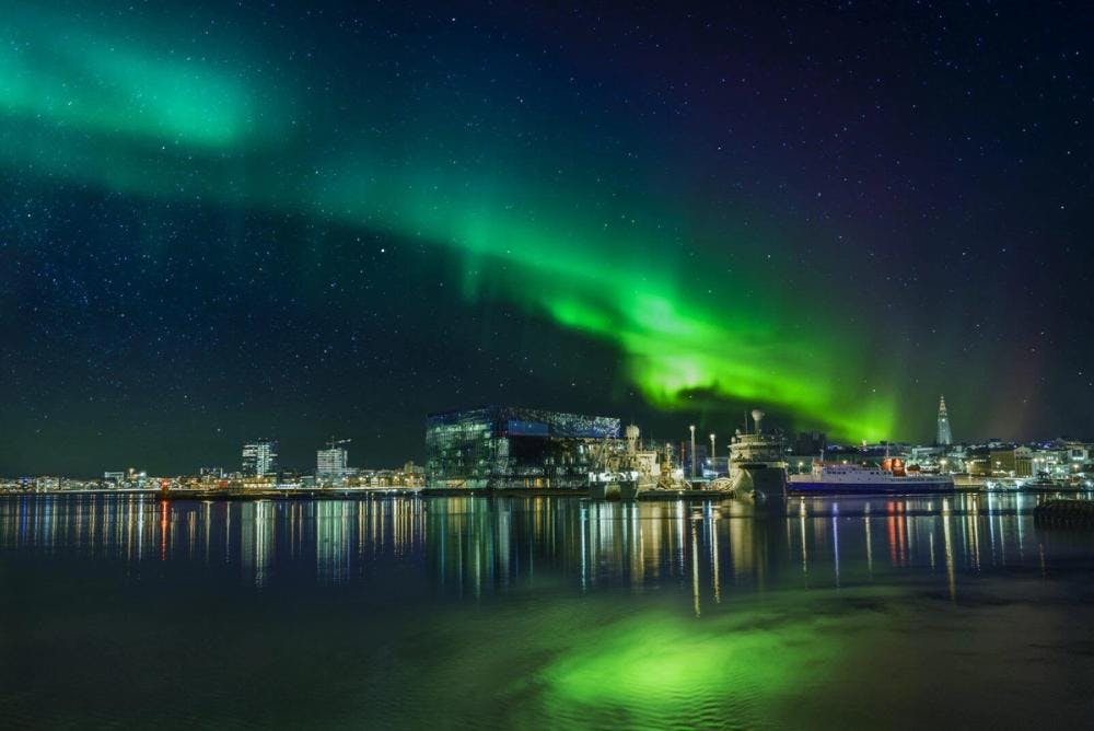 Northern Lights and Reykjavík Across the Sea